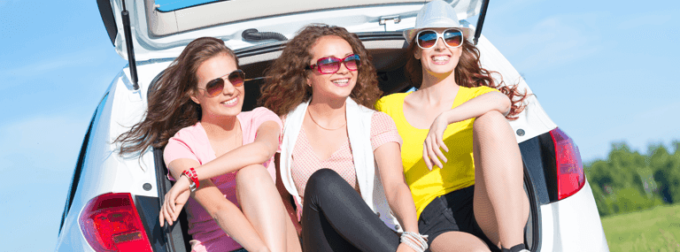 friends siting in open boot of car
