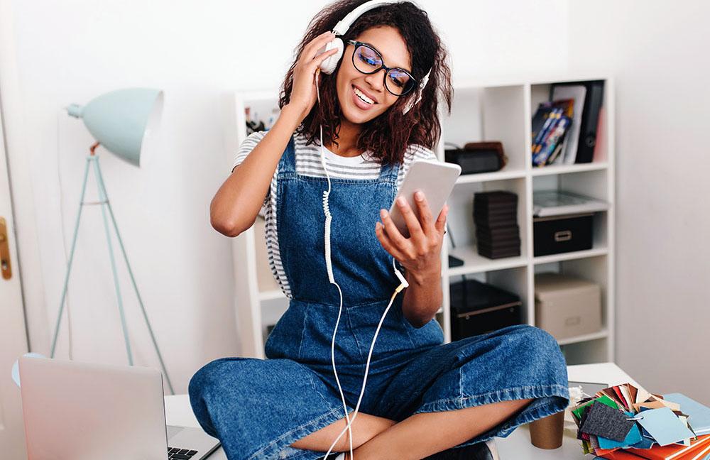 Girl listening to music in front of bookcase